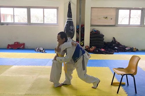 Taekwondo Coach hugging my daughter who passed her yellow belt