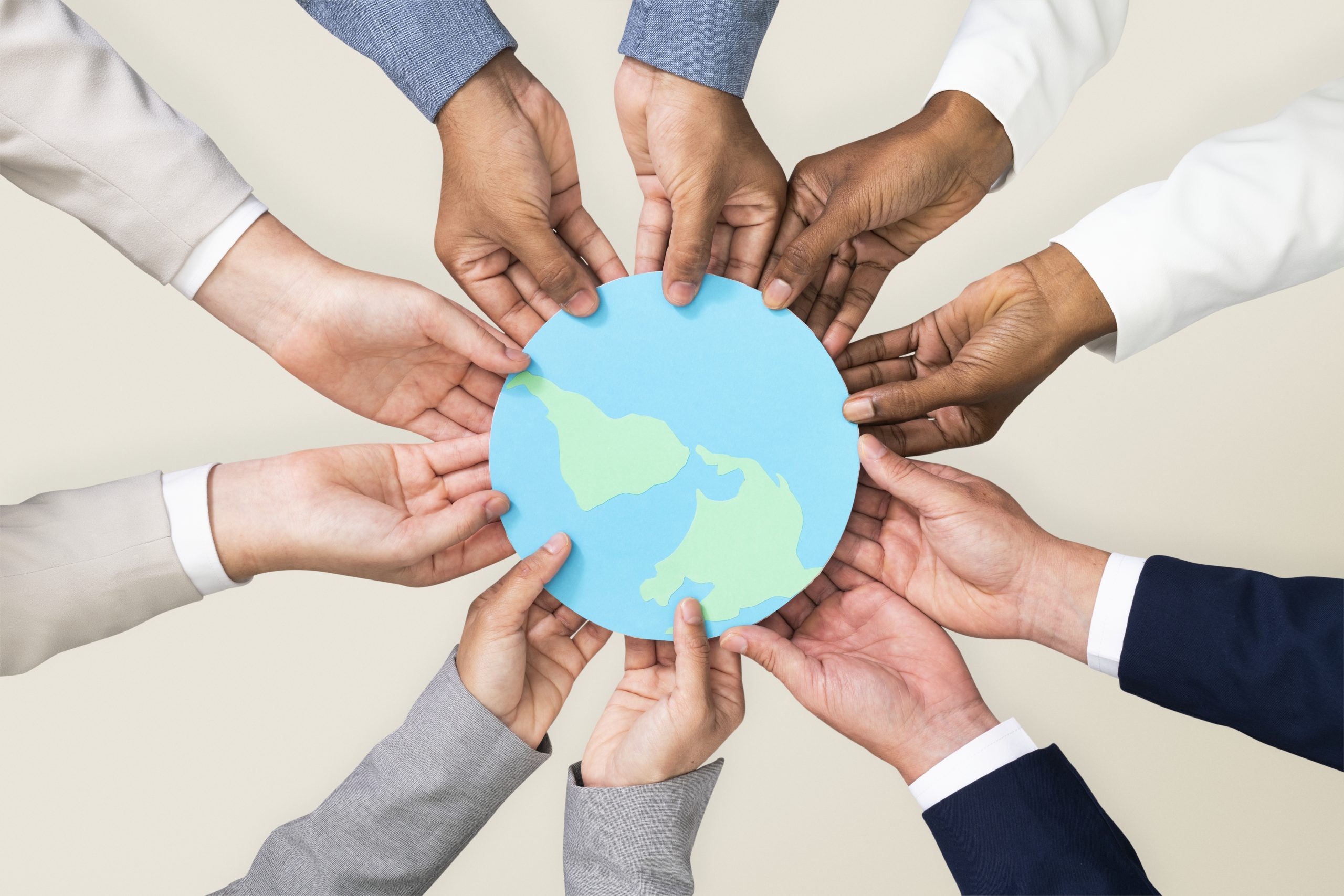 variety of coloured hands holding the world to demonstrate that all nations and races can live together. Multicultural coaching is here to help people understand, acknowledge and use their differences of culture efficiently and peacefully.